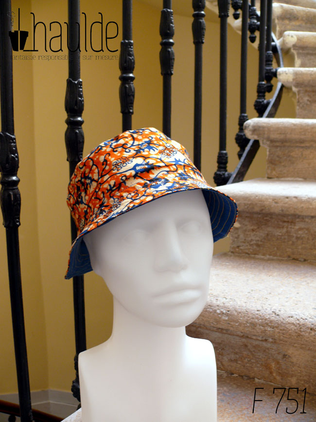 Bob court en tissu imprimé orange, motifs végétaux stylisés bleus roi et blancs L'envers est en sergé bleu roi Vu de trois quarts face sur une tête de mannequin