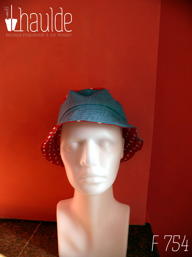 Bob court en jean bleu clair et tissu rouge à pois blanc, réversible, vu côté jean (le dessus du chapeau est en tissu rouge à pois) de face sur une tête de mannequin