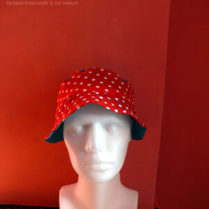 Bob court en tissu rouge à pois blanc et jean bleu clair. Réversible, vu côté rouge à pois, le dessus du chapeau est en jean. De face sur une tête de mannequin