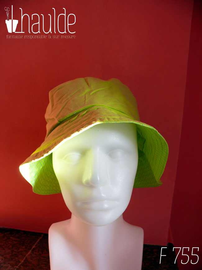 Bob en coton vert anis, réversible sur une face de la même couleur avec des yeux de grenouille en tissu sur le dessus et le rebord en tissu vert avec des lignes de losanges un peu plus foncé Vu de face sur une tête de mannequin