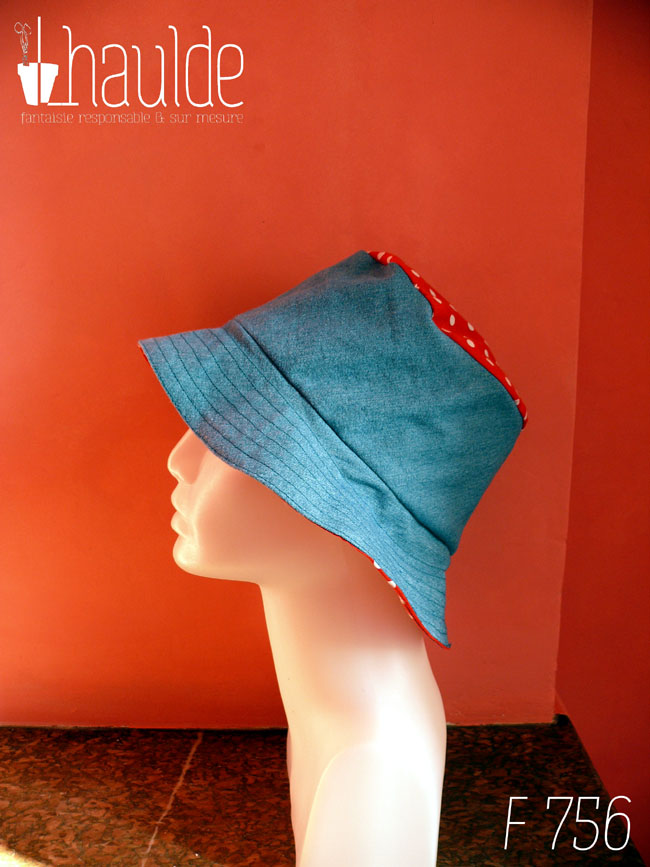 Bob en jean bleu clair et tissu rouge à pois blanc, réversible, vu côté jean (le dessus du chapeau est en tissu rouge à pois) de profil sur une tête de mannequin