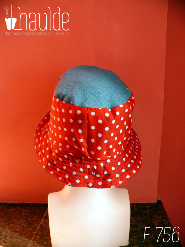 Bob en tissu rouge à pois blanc et jean bleu clair. Réversible, vu côté rouge à pois, le dessus du chapeau est en jean. De dos sur une tête de mannequin