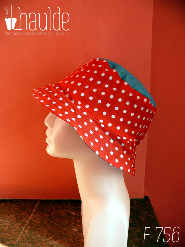Bob en tissu rouge à pois blanc et jean bleu clair. Réversible, vu côté rouge à pois, le dessus du chapeau est en jean. De profil sur une tête de mannequin