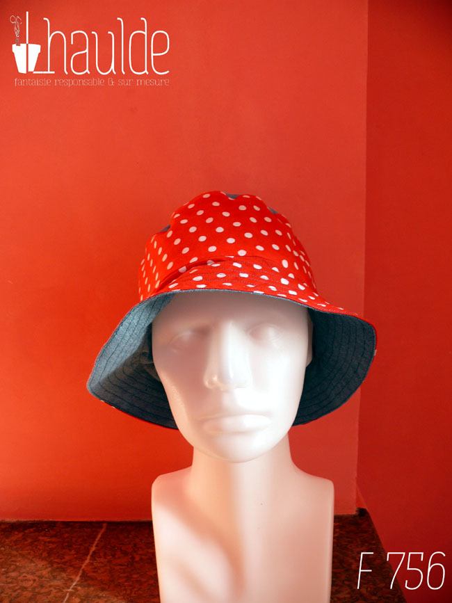 Bob en tissu rouge à pois blanc et jean bleu clair. Réversible, vu côté rouge à pois, le dessus du chapeau est en jean. De face sur une tête de mannequin