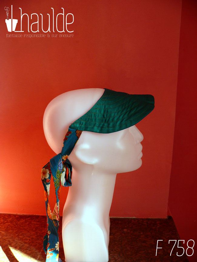 Visière côté vert émeraude nouée à l'arrière de la tête par des rubans bleu paon imprimé fleuri d'esthétique chinoise, dahlias et autres fleurs multicolores rehaussées de doré Vue de profil sur une tête de mannequin