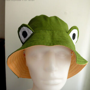 Bob grenouille vert avec des yeux en tissu cousus dessus L'intérieur est jaune Vu de face sur une tête de mannequin