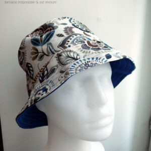 Bob en toile blanche imprimée de motifs appelés "mabelle" fleurs stylisées d'inspiration indienne dans les tons bleu et marrons Vu de face sur une tête de mannequin