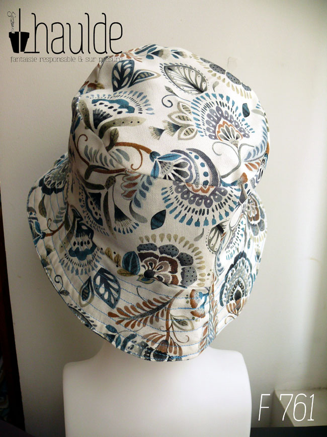 Bob en toile blanche imprimée de motifs appelés "mabelle" fleurs stylisées d'inspiration indienne dans les tons bleu et marrons Vu de dos sur une tête de mannequin