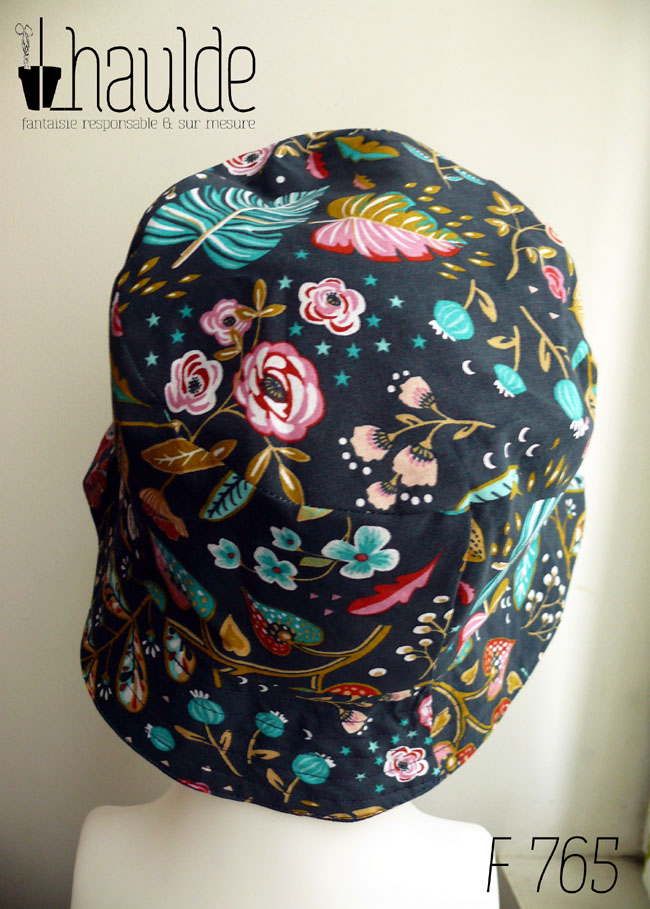 Bob en toile bleu marine imprimée de motifs fleuris dans les tons roses, bleu turquoise et rouge Vu de dos sur une tête de mannequin