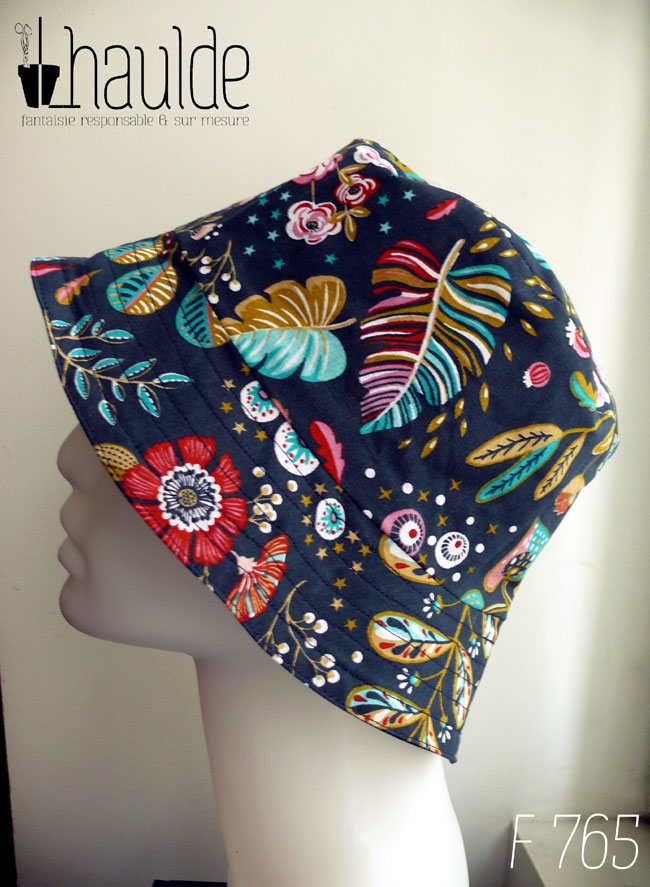 Bob en toile bleu marine imprimée de motifs fleuris et feuillus dans les tons roses, bleu turquoise et rouge Vu de profil sur une tête de mannequin