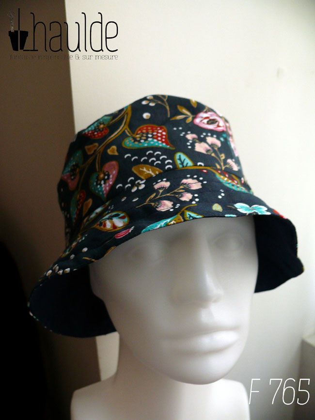 Bob en toile bleu marine imprimée de motifs fleuris dans les tons roses, bleu turquoise et rouge Vu de face sur une tête de mannequin