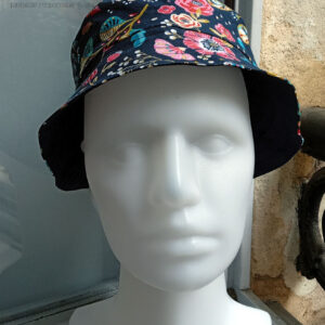 Bob court en toile bleu marine imprimée de motifs fleuris dans les tons roses, bleu turquoise et rouge Vu de face sur une tête de mannequin