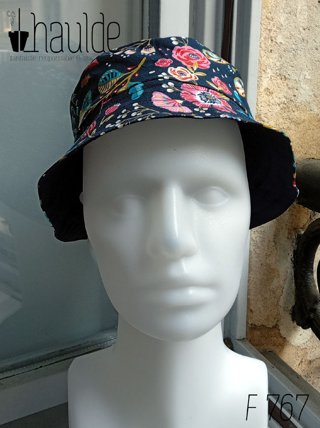 Bob court en toile bleu marine imprimée de motifs fleuris dans les tons roses, bleu turquoise et rouge Vu de face sur une tête de mannequin