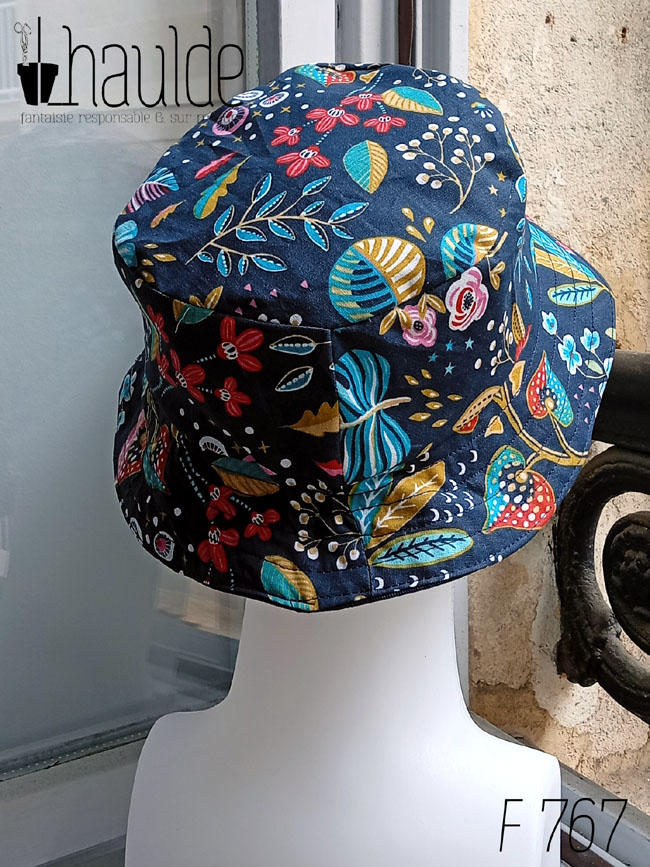 Bob court en toile bleu marine imprimée de motifs fleuris dans les tons roses, bleu turquoise et rouge Vu de dos sur une tête de mannequin