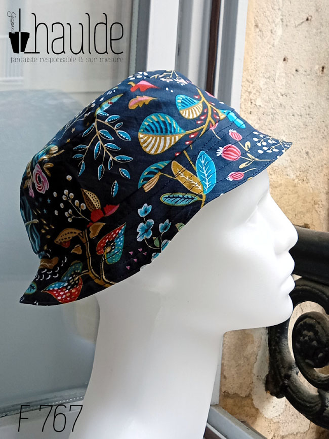 Bob court en toile bleu marine imprimée de motifs fleuris dans les tons roses, bleu turquoise et rouge Vu de profil sur une tête de mannequin