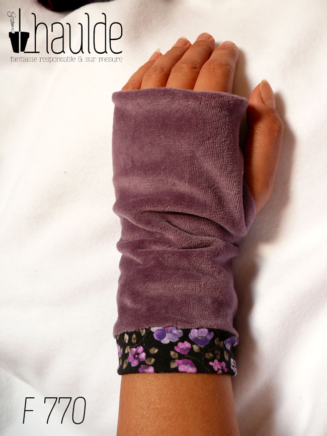 Mitaines en jersey noir, manchettes en tissu noir imprimé de petites fleurs violettes et en velours mauve Vue d'une mitaine portée sur l'envers, côté velours mauve, la manchette en jersey imprimé