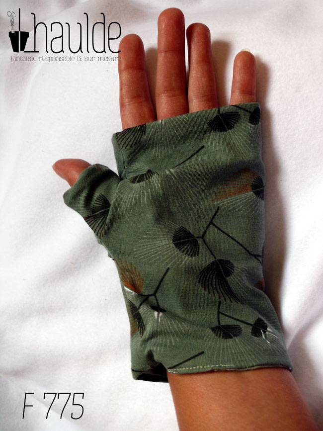 Mitaines en jersey vert céladon imprimé de motifs végétaux en forme de feuilles de palmes stylisées et aérées. Le pouce est couvert Vue d'une mitaine portée, côté paume