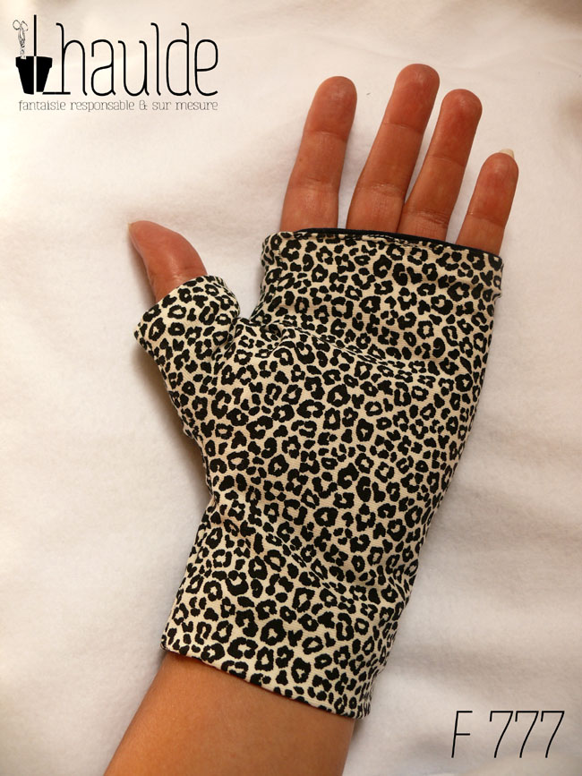 Paire de mitaines en jersey écru imprimé de petits motifs léopard noir avec le pouce long Vue de dessus côté paume. Elles descendent jusqu'en dessous du poignet