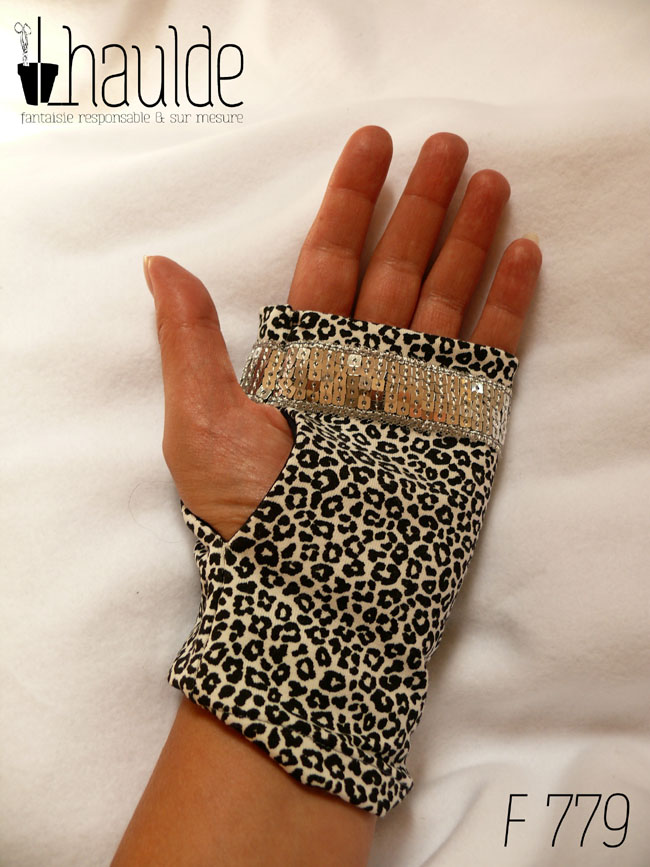 Paire de mitaines en jersey écru imprimé de petits motifs léopard noir. Avec au niveau des phalanges un galon de sequins carrés argentés sur 5 rangs Vue de dessus côté paume