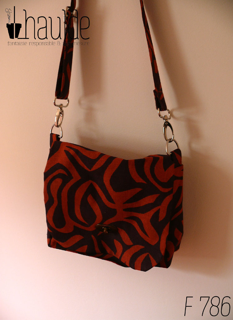 sac en tissu marron avec des motifs zèbre oranges foncés. Vu suspendu, fermé par son tourniquet couleur bronze Bandoulière réglable et amovible (sur mousquetons)